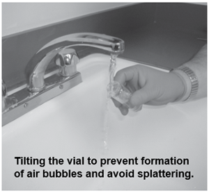 Someone holding a vial at an angle under a faucet. 