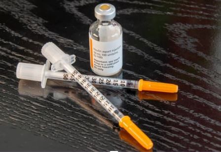Insulin bottle with two syringes