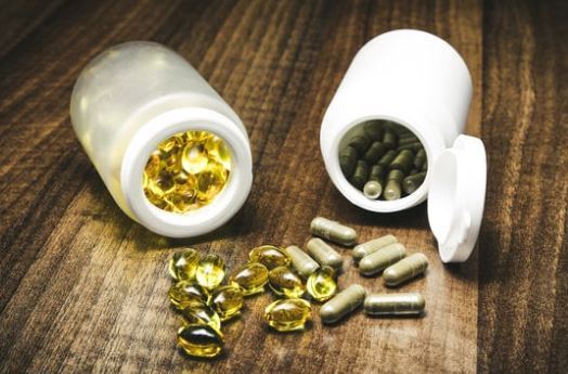 Image of two opened bottles of pills, both vitamins and supplements