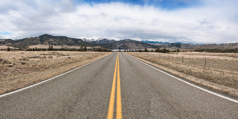 paved road with mountains in background