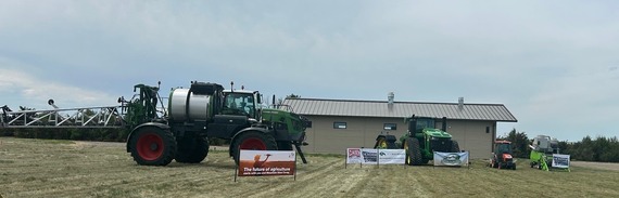 Tractors in front of shop with banners staked in front of them.