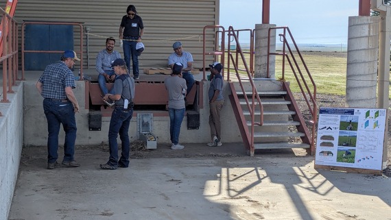 Group of men standing around Kazi on loading dock