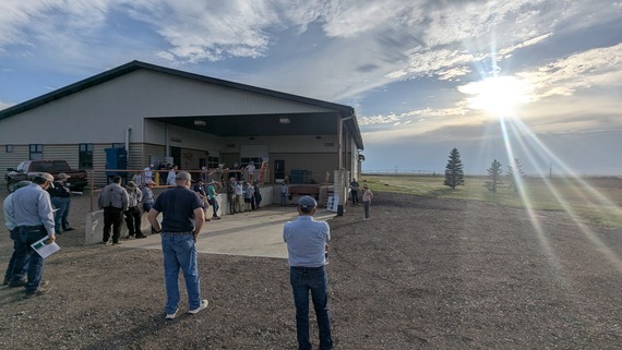 People standing in front of building while Jennie speaks