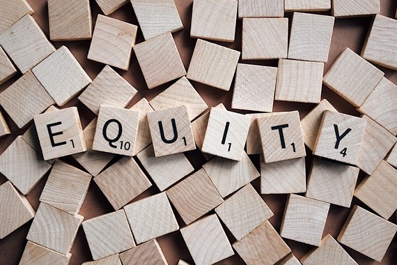 The word "Equity" spelled with Scrabble tiles