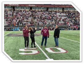 Teacher of the Year Bill Stockton at the Brawl of the Wild on the football field with Superintendent Arntzen and U of M staff