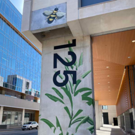 Bee and plant painted on a column at 125 E Rosemary St parking deck