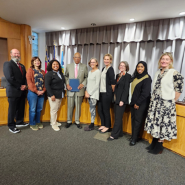 Council Members standing at dais with Former Mayor Howard Lee