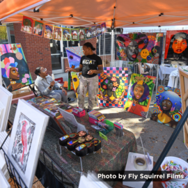 Art vendor with paintings at festifall arts market