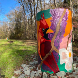 Aboveground sewer pipe with painting of cardinal and magnolia along the Bolin Creek