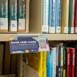 Sign that says Book Club Ready attached to a shelf of books