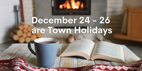 Coffee and book on table with firewood and fire place in the background