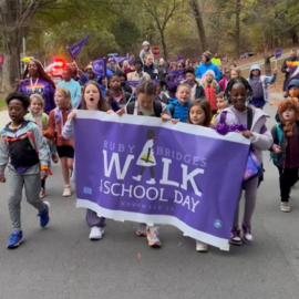 Children walking with Ruby Bridges Walk to School Day banner