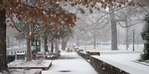 Wintry scene at sidewalk on campus on Franklin Street with two people walking