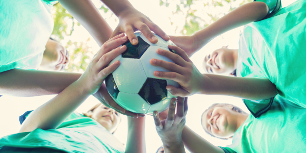 Picture from the ground up of children holding a soccer ball