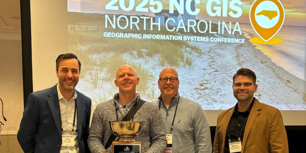 GIS staff members holding award at GIS conference