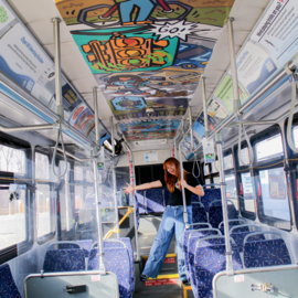 Person on bus with art on the ceiling