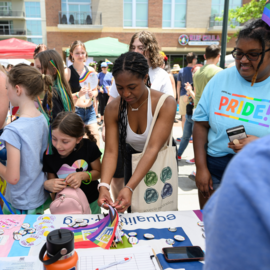 People at a table of Pride memorabilia 