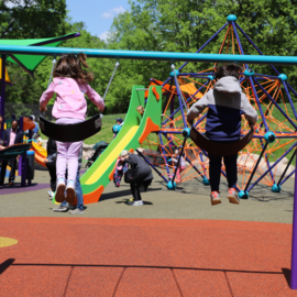 Children swinging on swings at Community Center park