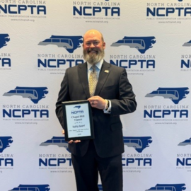 Chapel Hill Transit Director Brian Litchfield holding an award