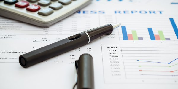 Pen and calculator sitting on top of budget documents