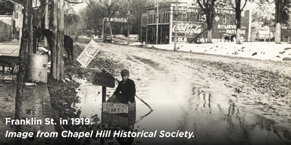 1919 image of a child in a makeshift boat on muddy Franklin St