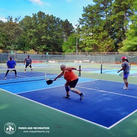 People with pickleball paddles on a pickleball court