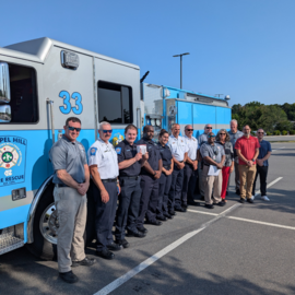 Chapel Hill Fire professionals with State Farm insurance professionals in front of carolina blue engine 33
