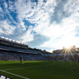 Person kicking soccer ball on Kenan Stadium field