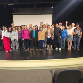Group of people standing on a stage smiling
