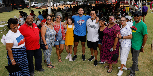 Group of people with arms around each other's shoulders at Juneteenth celebration