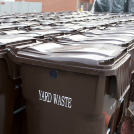 Brown rolling bin that says Yard Waste