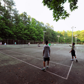 People playing tennis on old Cedar Falls Tennis court