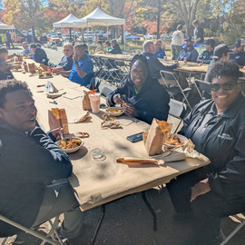 People sitting at a table smiling and eating
