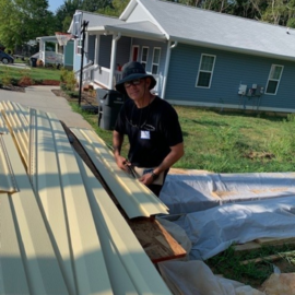 Employee working on a house with siding