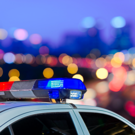 Police car at night with a blurred city backdrop