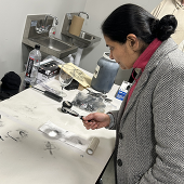 Person using magnifying glass to look at clues on a table