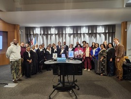 Council and community members standing in front of dais in council chamber to receive Black History month proclamation