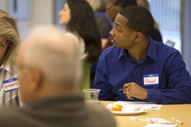 Board member sitting at a table looking up at a screen