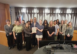 Community members, Town staff, and Council members standing in front of Council dais with Women's History proclamation