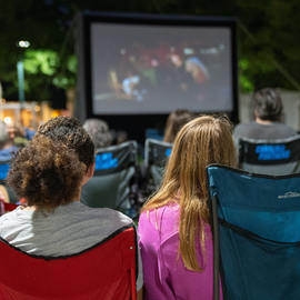 People watching a movie under the stars as part of Community Arts and Culture's summer event season