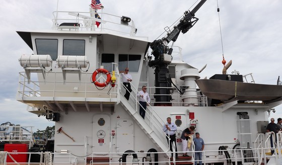 Image of Chairman Woodard and other men riding the Miss Katie into the harbor.