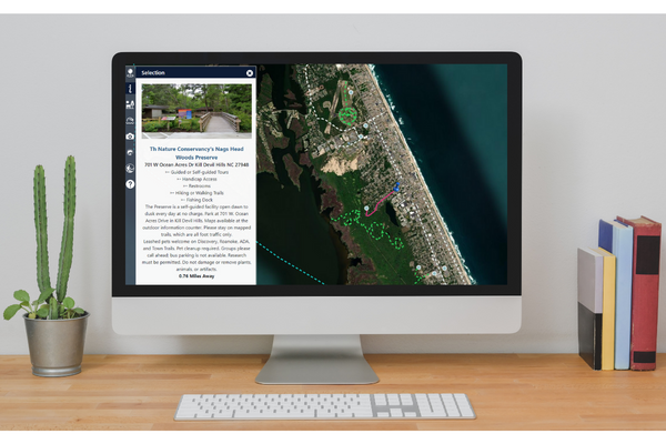 Image of a computer sitting on a desk. The screen showcases the Recreation walking trails maps.