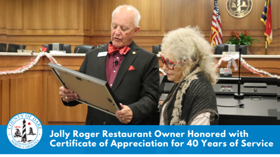 Image: Bob Woodard presents plaque to Carol Ann. "Jolly Roger Restaurant Owner Honored with Certificate of Appreciation for 40 Years Service"