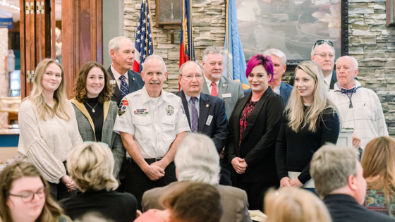 Image of the guest speakers and Board of Commissioners standing together in front of the room.