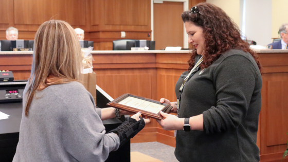 Image of Elizabeth Reilly handing a plaque to 2022 Employee of the Year, Amy Elkins.