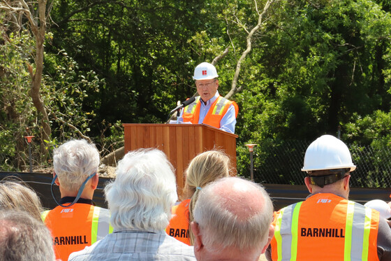 Image of Wally Overman standing at a podium speaking to the crowd.