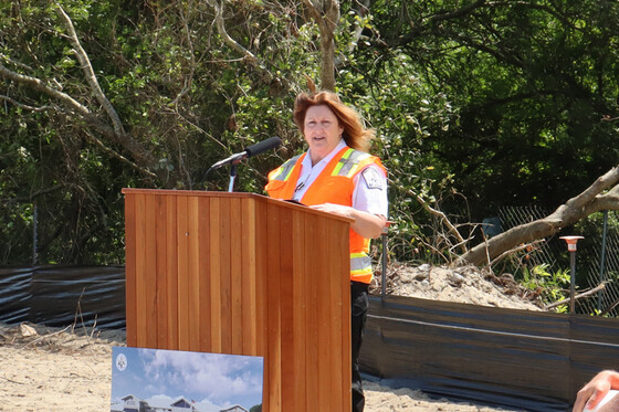 Image of Chief Jennie Collins standing at a podium speaking to the crowd.