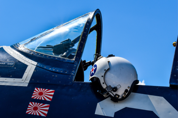 Image of a plane with an antique helmet sitting alongside the cockpit entrance.