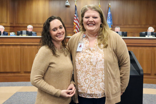 Image of Allison and Beth Bradley standing in front of the Dare County Board of Commissioners' podium.