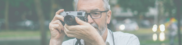 Image of a senior man taking a photo.